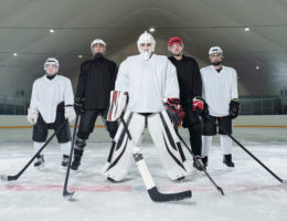 Professional hockey players and their trainer in sports uniform and skates